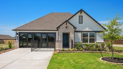 Liberty Village model home with white farmhouse exterior and brick masonry.