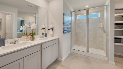 Liberty Village primary bathroom with quartz dual vanity and light gray cabinetry.