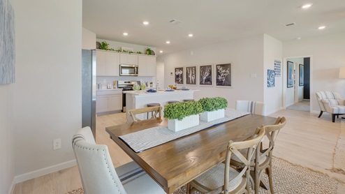 Liberty Village open concept dining space with dinner table and view to kitchen.