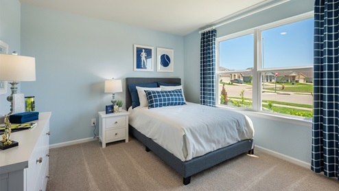 Liberty Village secondary bedroom with window, carpeted flooring, and bed.