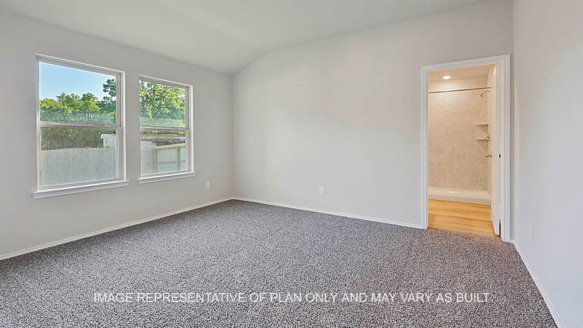Elgin primary bedroom with windows, carpeted flooring, and view to bathroom.