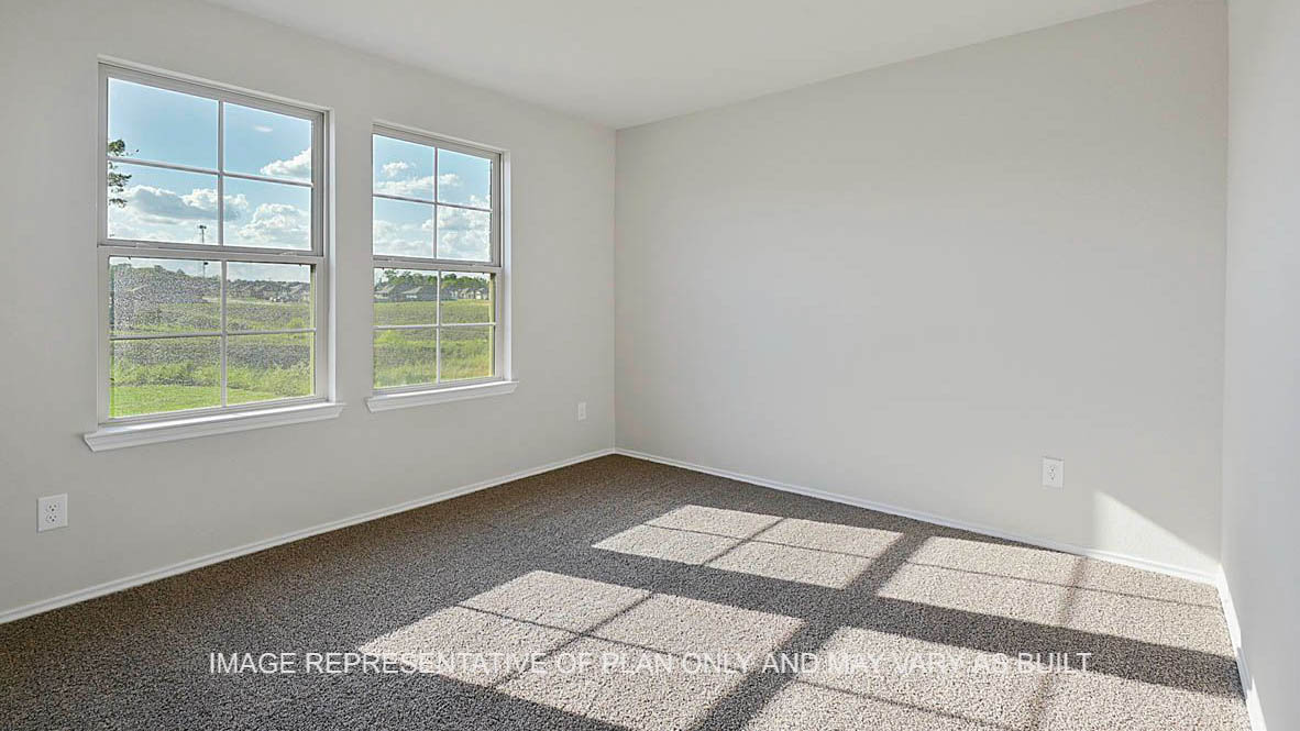Texas Cali secondary bedroom with window and carpet flooring.