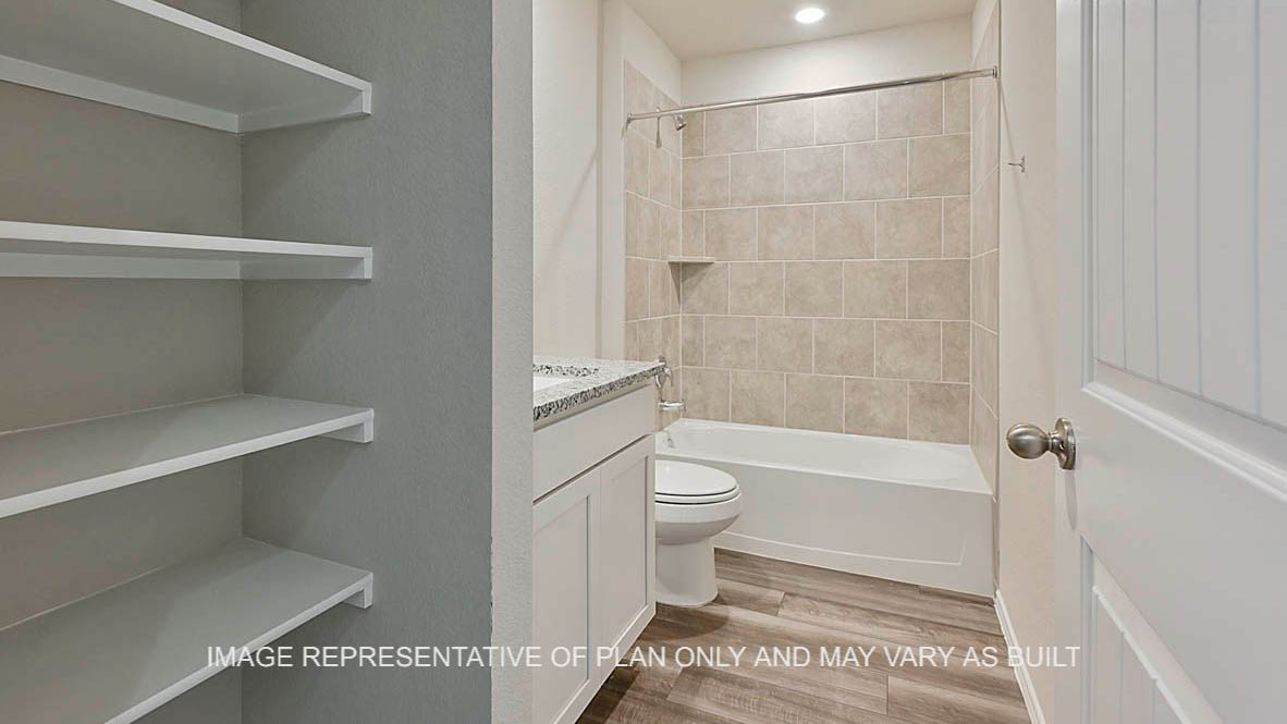 Kingston secondary bathroom with white cabinetry and shelving, granite countertops, ceramic tile shower bath surround, and vinyl plank flooring.