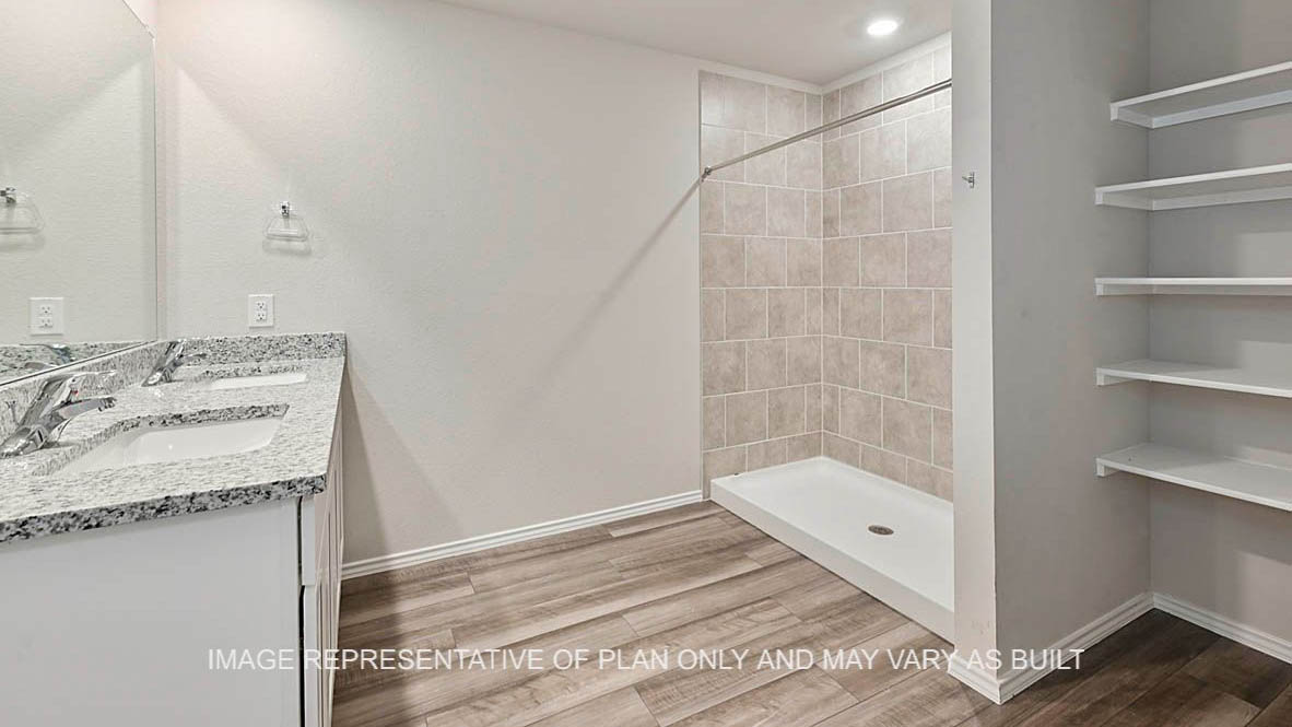 Kingston primary bathroom with white cabinetry, granite countertops, ceramic tile shower surround, and vinyl plank flooring.