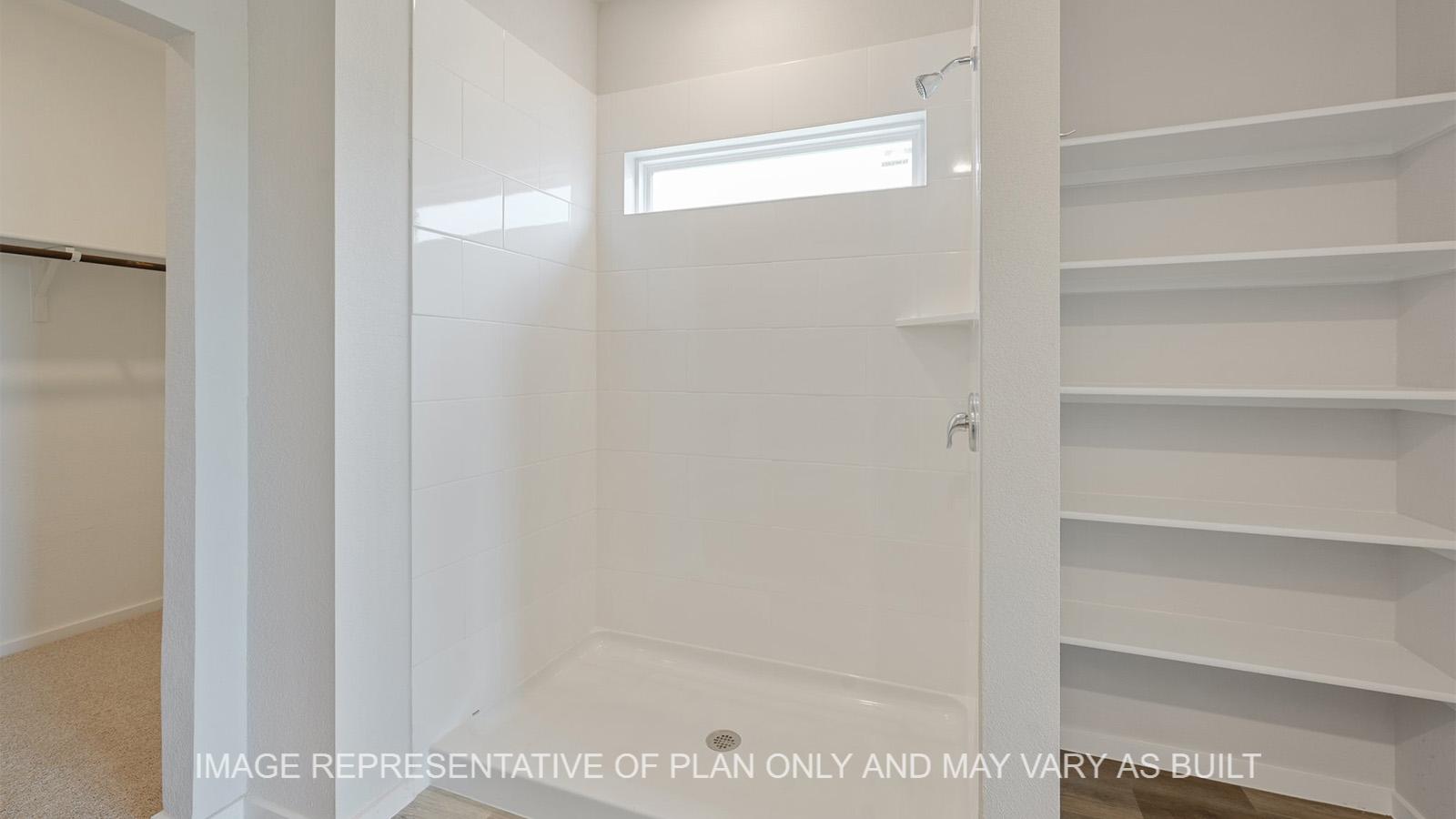 Midland primary bathroom with gray cabinetry, granite countertops, linen shelving, ceramic tile shower surround, and vinyl plank flooring.