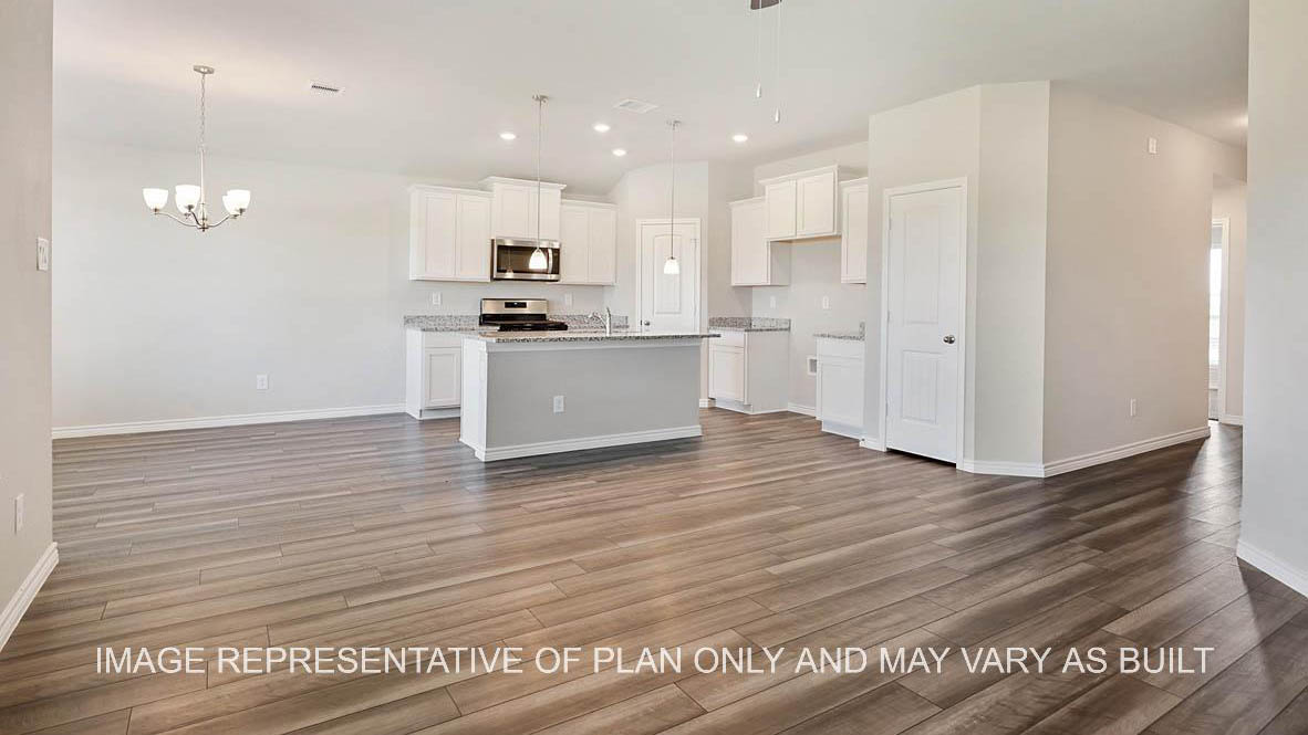 Auburn open-concept living room with view to kitchen and vinyl plank flooring.