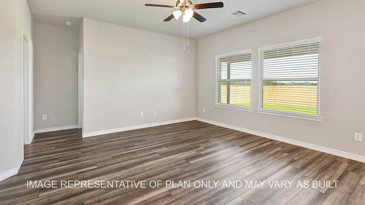 Auburn open-concept living room with double windows viewing the backyard, ceiling fan and vinyl plank flooring.