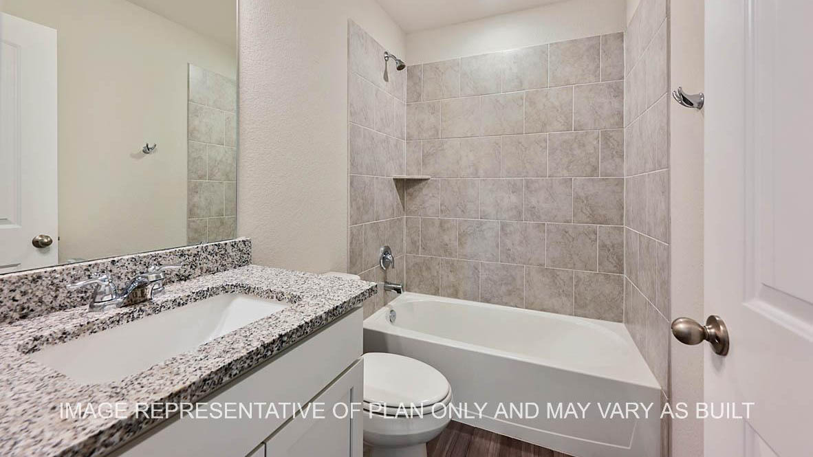 Auburn secondary bathroom with white cabinets, granite countertops, ceramic tile shower and bath surround, and vinyl plank flooring.
