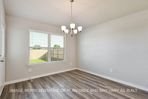 Auburn open-concept dining room with back door, window with a view to the backyard, and vinyl plank flooring.