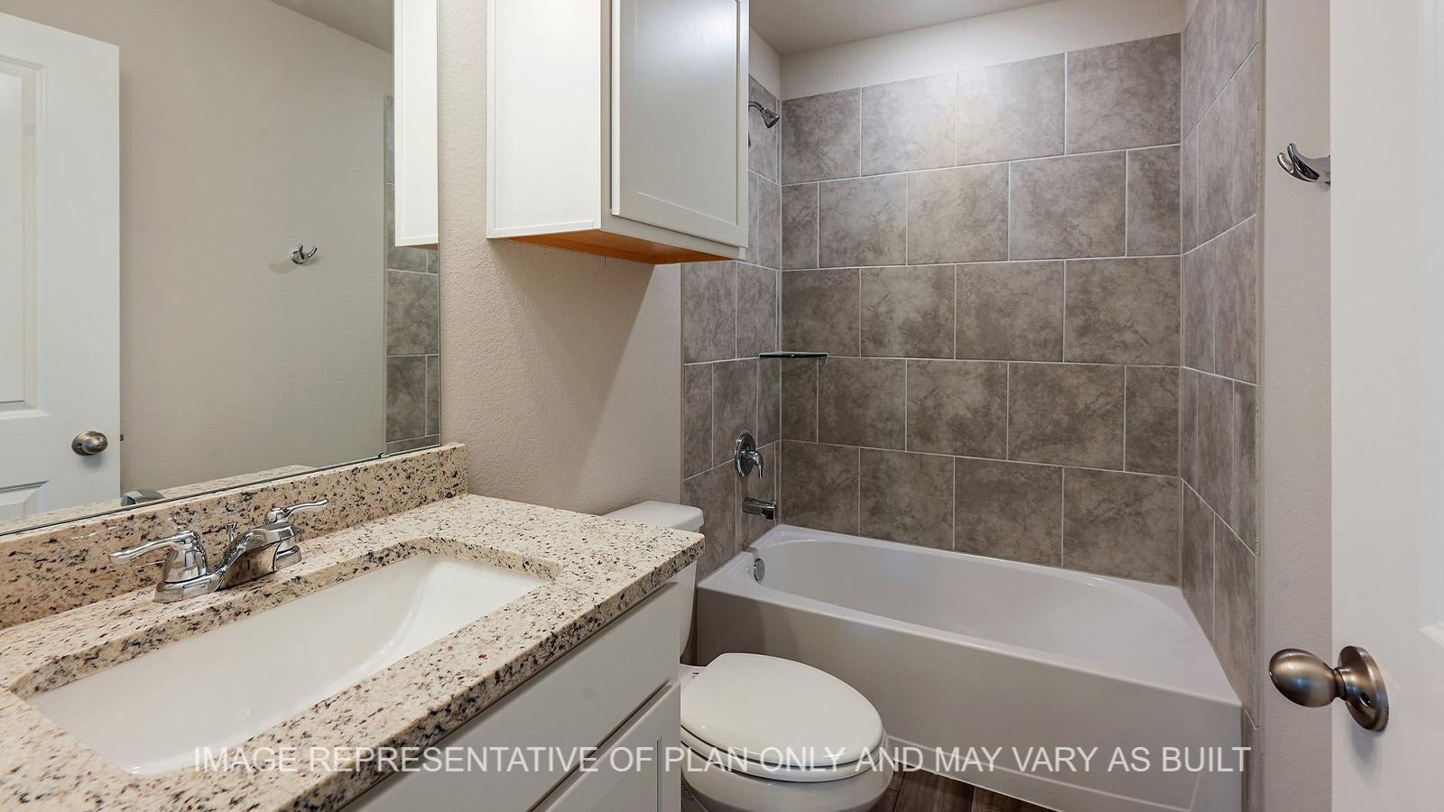 Alpine secondary bathroom with white cabinetry, ceramic tile shower tub surround, granite countertops, and vinyl plank flooring.