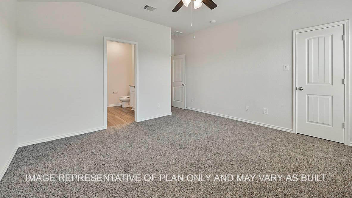 Roosevelt primary bedroom with carpet flooring and view into primary bath.