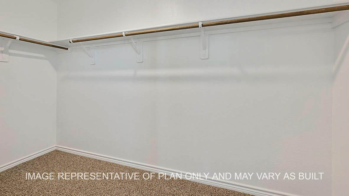 Roosevelt primary bedroom closet with carpet flooring.