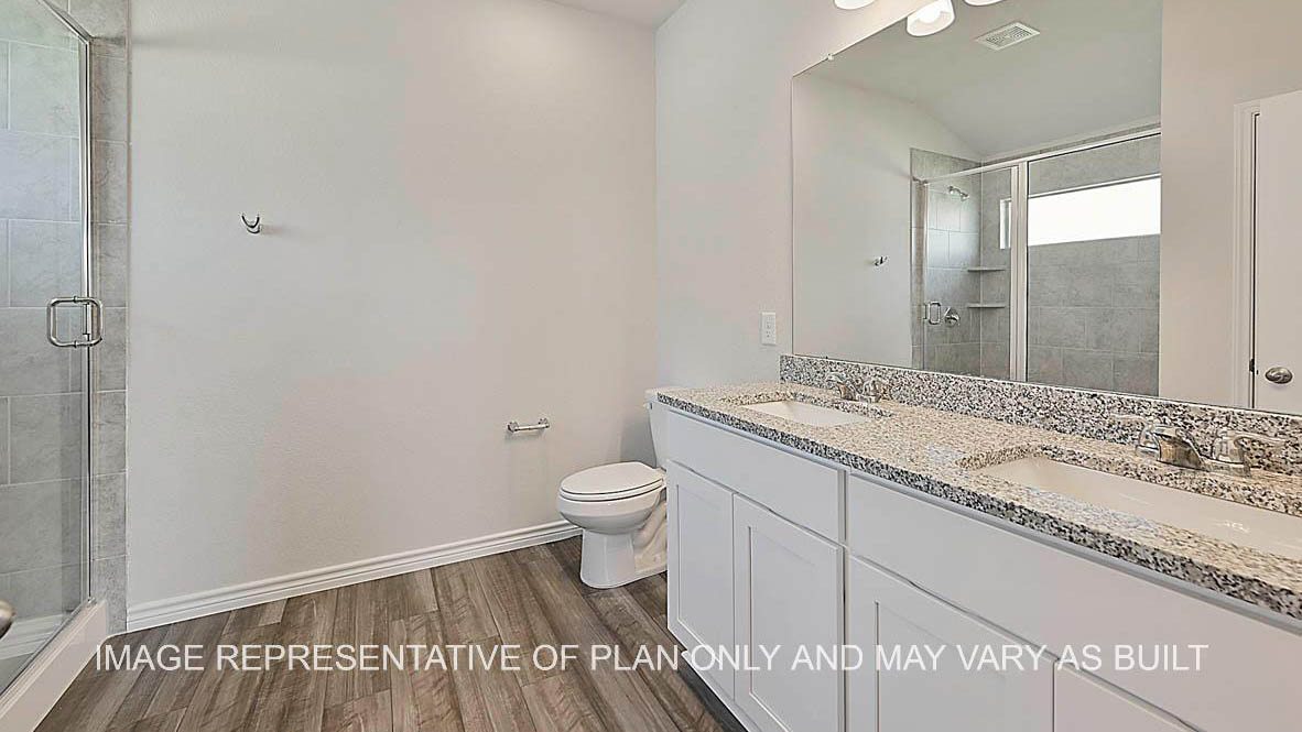 Roosevelt primary bathroom with white cabinets, granite countertops, ceramic tile shower surround and vinyl plank flooring.