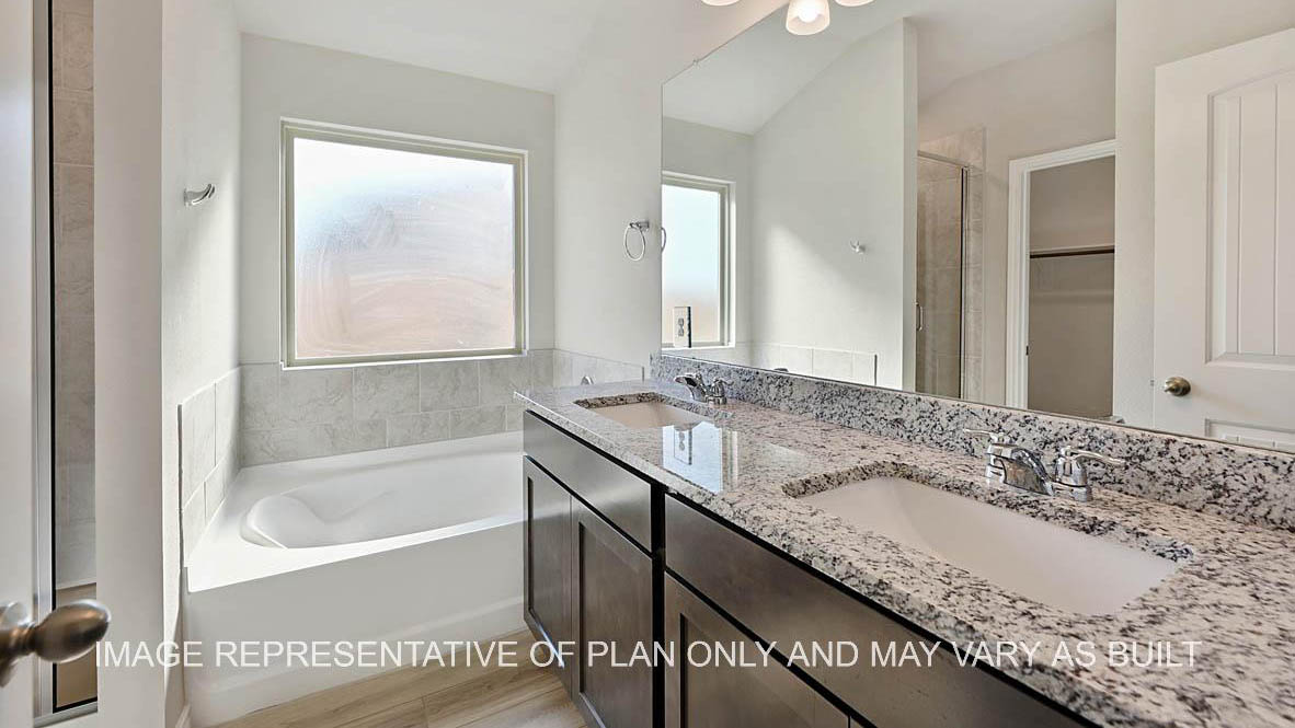 Richmond primary bathroom with dark cabinets, granite countertops, ceramic tile shower surround and vinyl plank flooring.