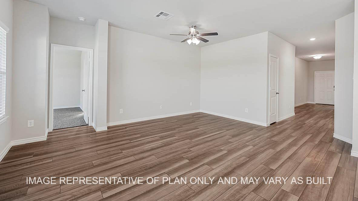 Prescott living room with view to front door and primary bedroom and vinyl plank flooring.