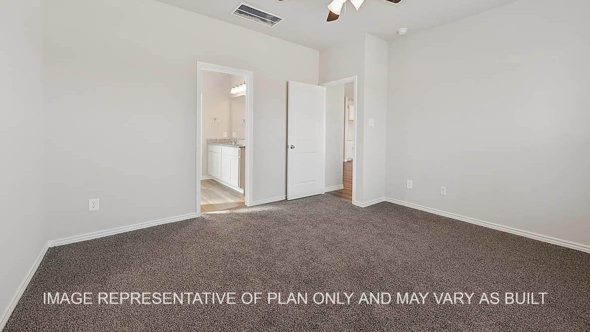 Prescott primary bedroom with view to bathroom and carpet flooring.