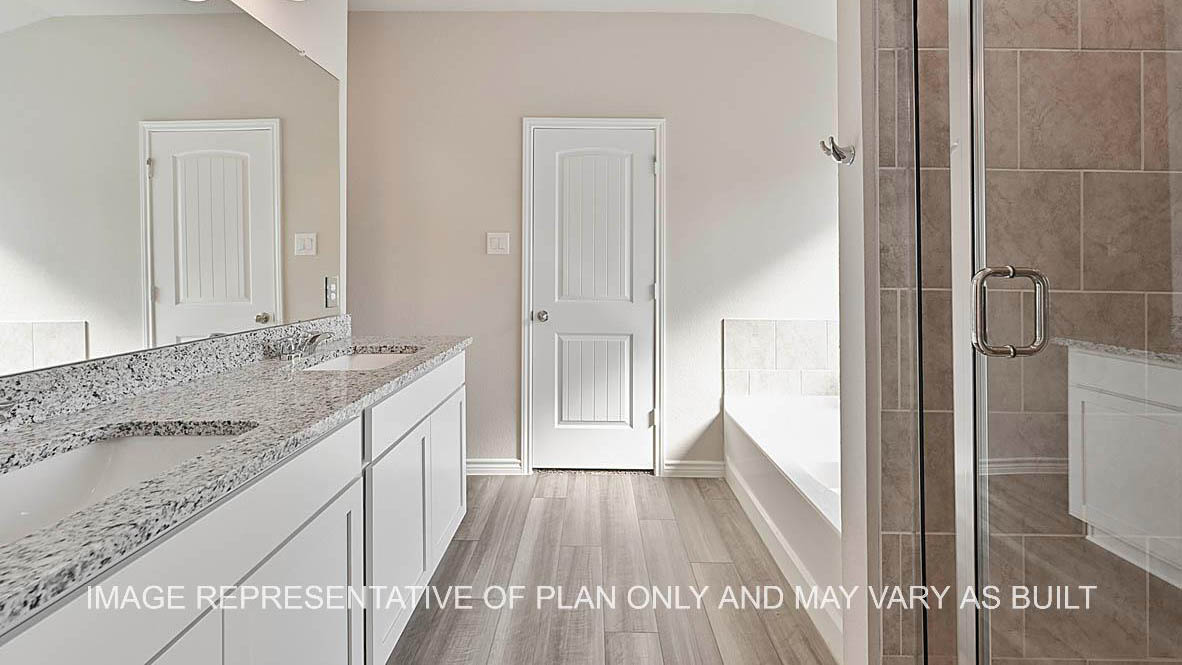 Prescott primary bathroom with vinyl plank flooring, separate tub and shower with ceramic tile surround, white cabinets and granite countertops.