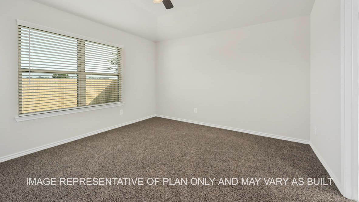 Prescott primary bedroom with backyard facing windows and carpet flooring.