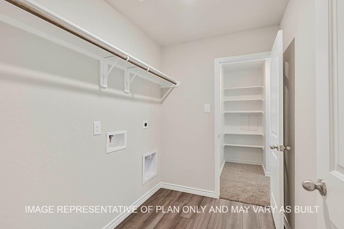 Prescott utility room with vinyl flooring and view to primary closet.