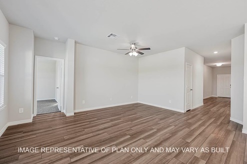 Prescott living room with view to front door and primary bedroom and vinyl plank flooring.