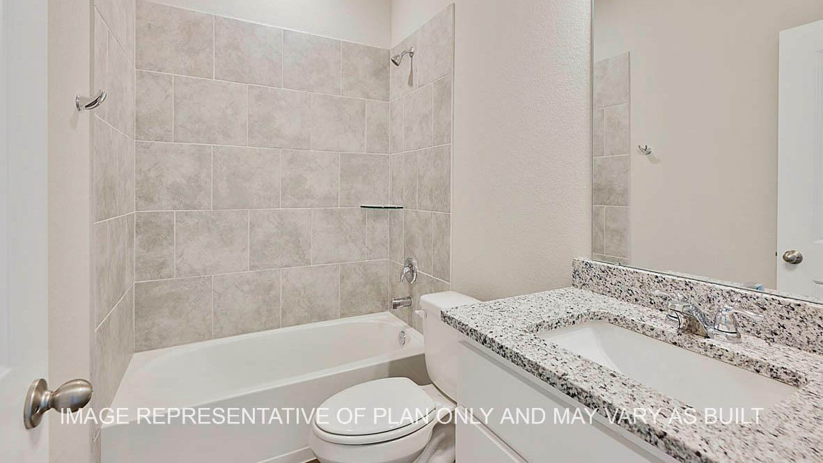 Kiawa secondary bathroom with granite countertops, white cabinetry, ceramic tile surround, and laminate flooring.