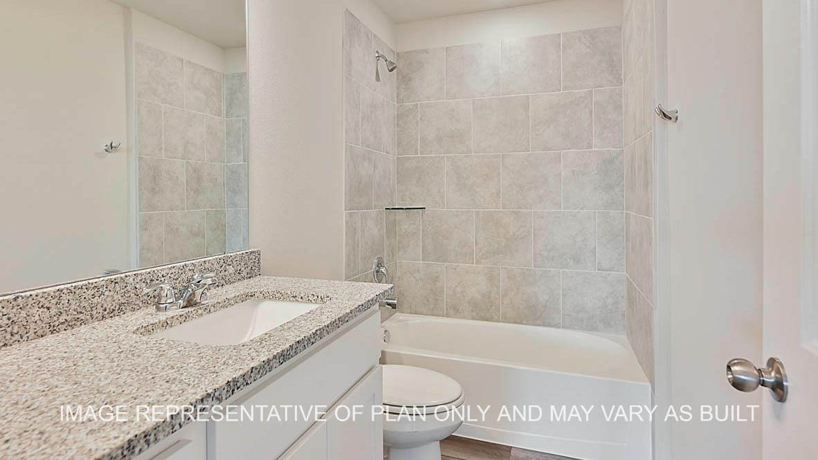 Kiawa secondary bathroom with granite countertops, white cabinetry, ceramic tile surround, and laminate flooring.