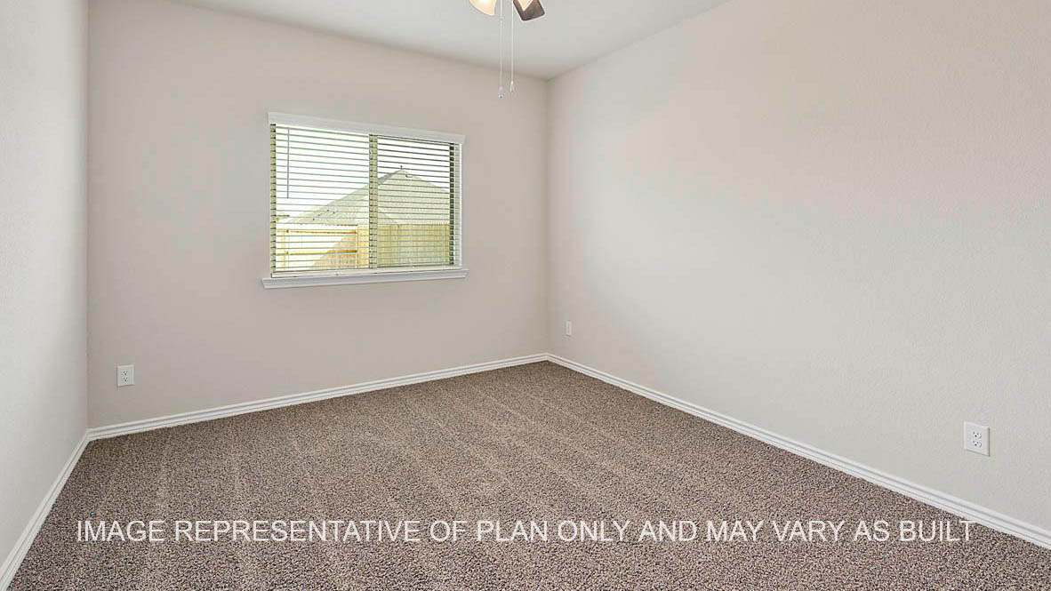 Kiawa secondary bedroom with window and carpeted flooring.