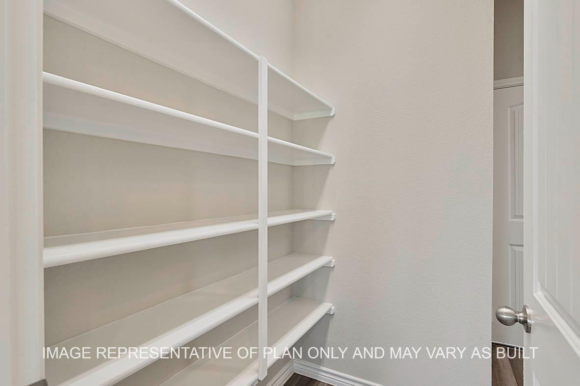 Kiawa pantry with shelving and vinyl plank flooring.