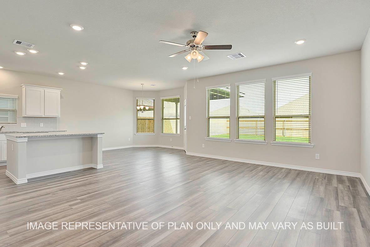 Kiawa open-concept family room with view to kitchen and breakfast nook and vinyl plank flooring.