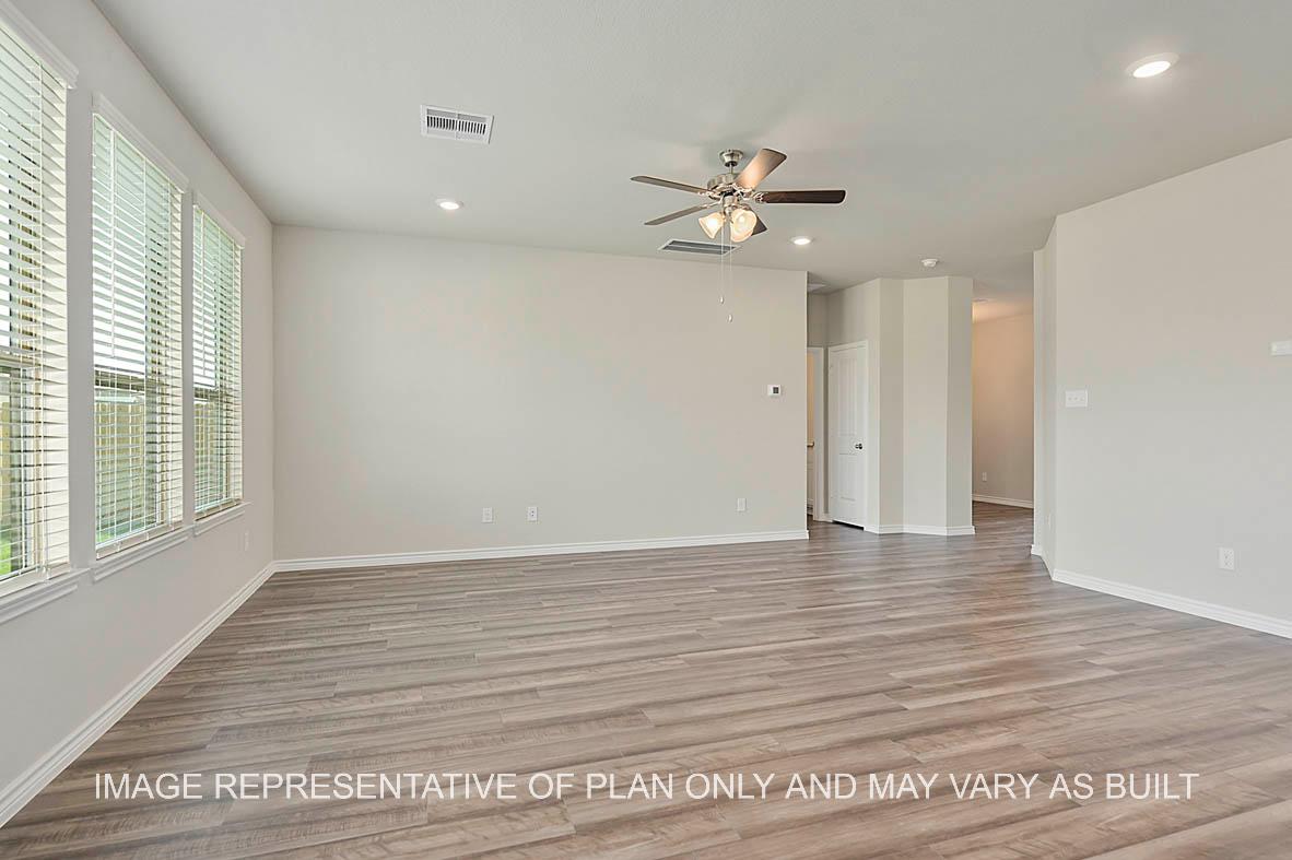 Kiawa open-concept family room with windows, vinyl plank flooring, and view to bedroom.