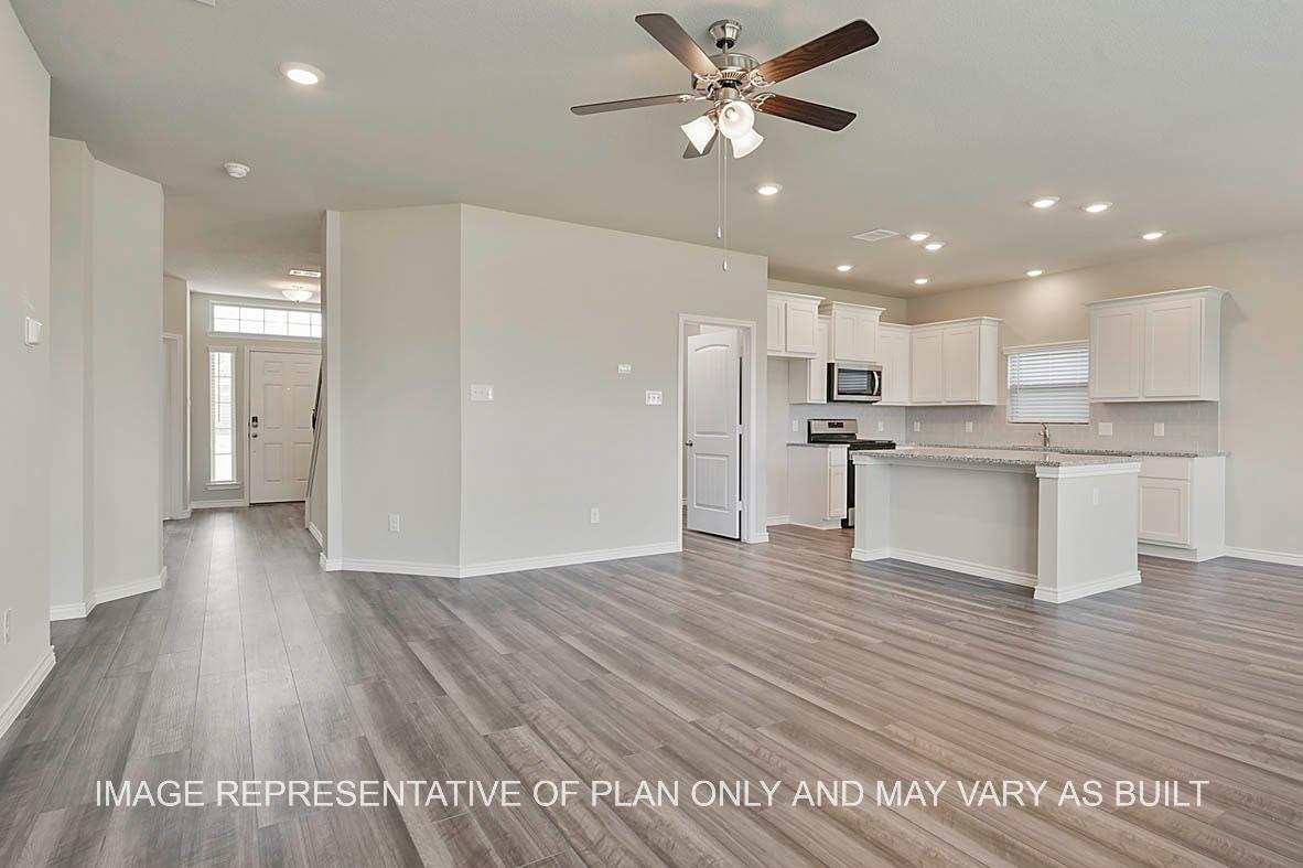 Kiawa open-concept family room with view to entry and kitchen and vinyl plank flooring.