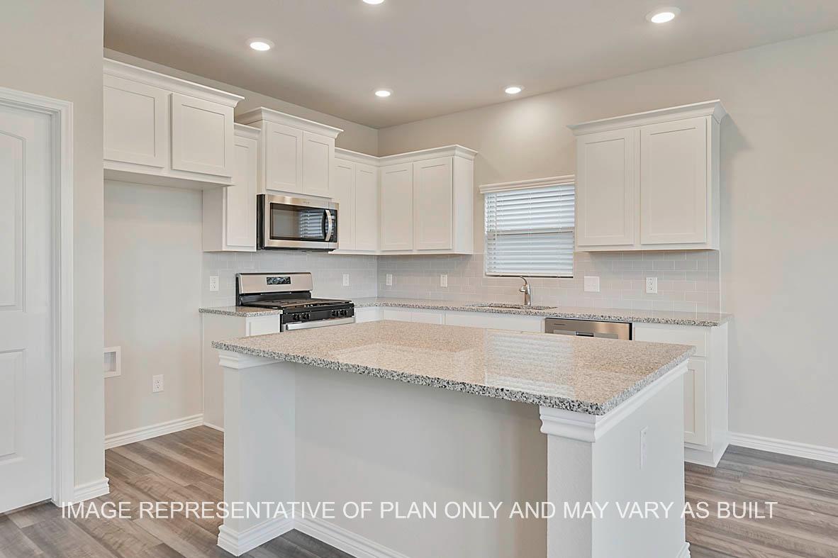 Kiawa kitchen with white cabinetry, granite countertops, tile backsplash, and kitchen island.