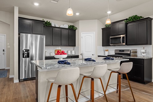 Southern Pointe model home with dark cabinetry, kitchen island, granite countertops, and corner pantry