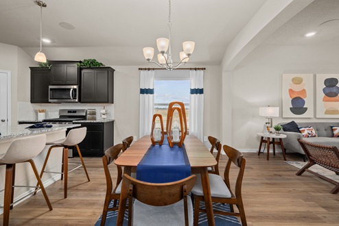 Southern Pointe model home open-concept dining area with dining table and windows