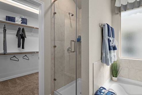 Southern Pointe model home primary bathroom with view to shower and walk-in closet