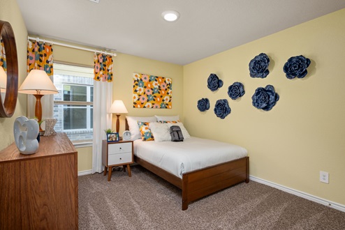 Southern Pointe model home furnished secondary bedroom with window and carpeted flooring