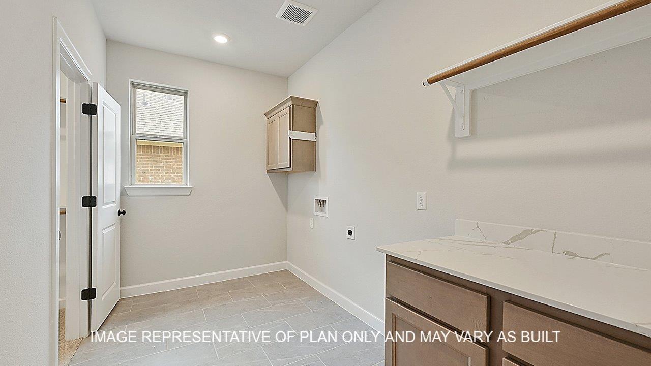 Brighton utility room with light stained cabinets, white quartz countertop with hanging rack for clothing.