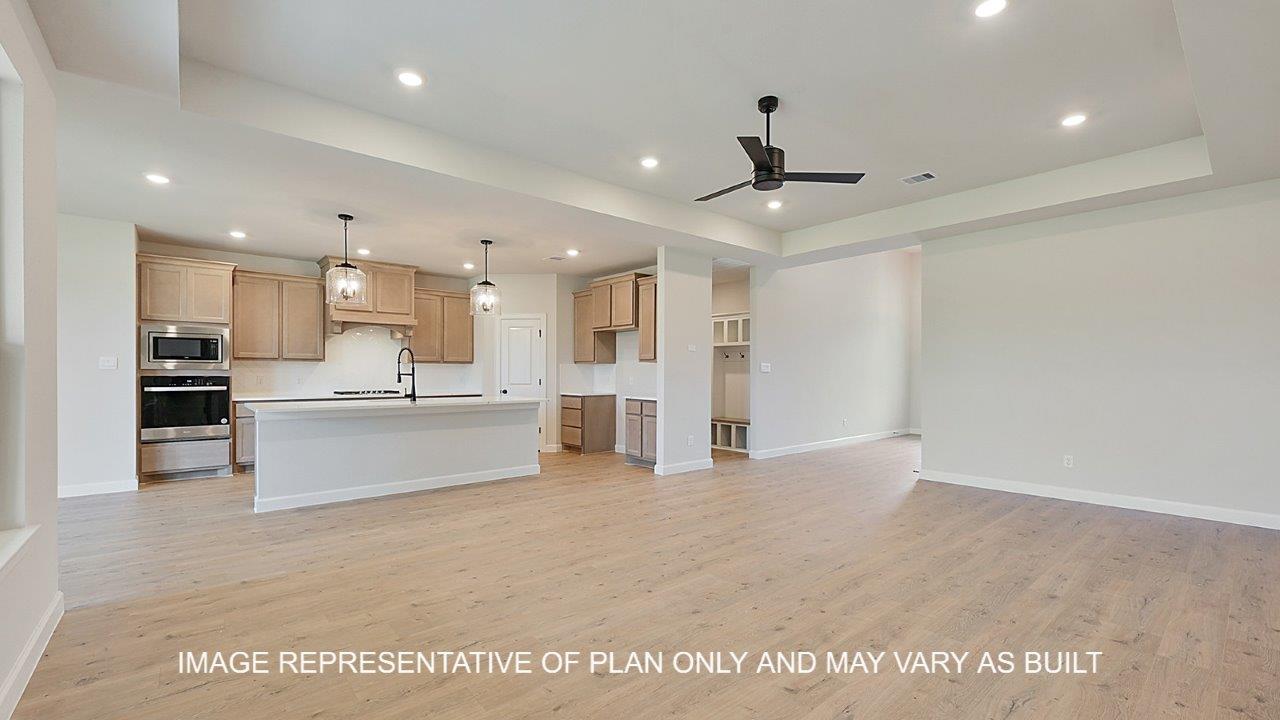 Brighton living room with laminate wood flooring and view of open concept kitchen.