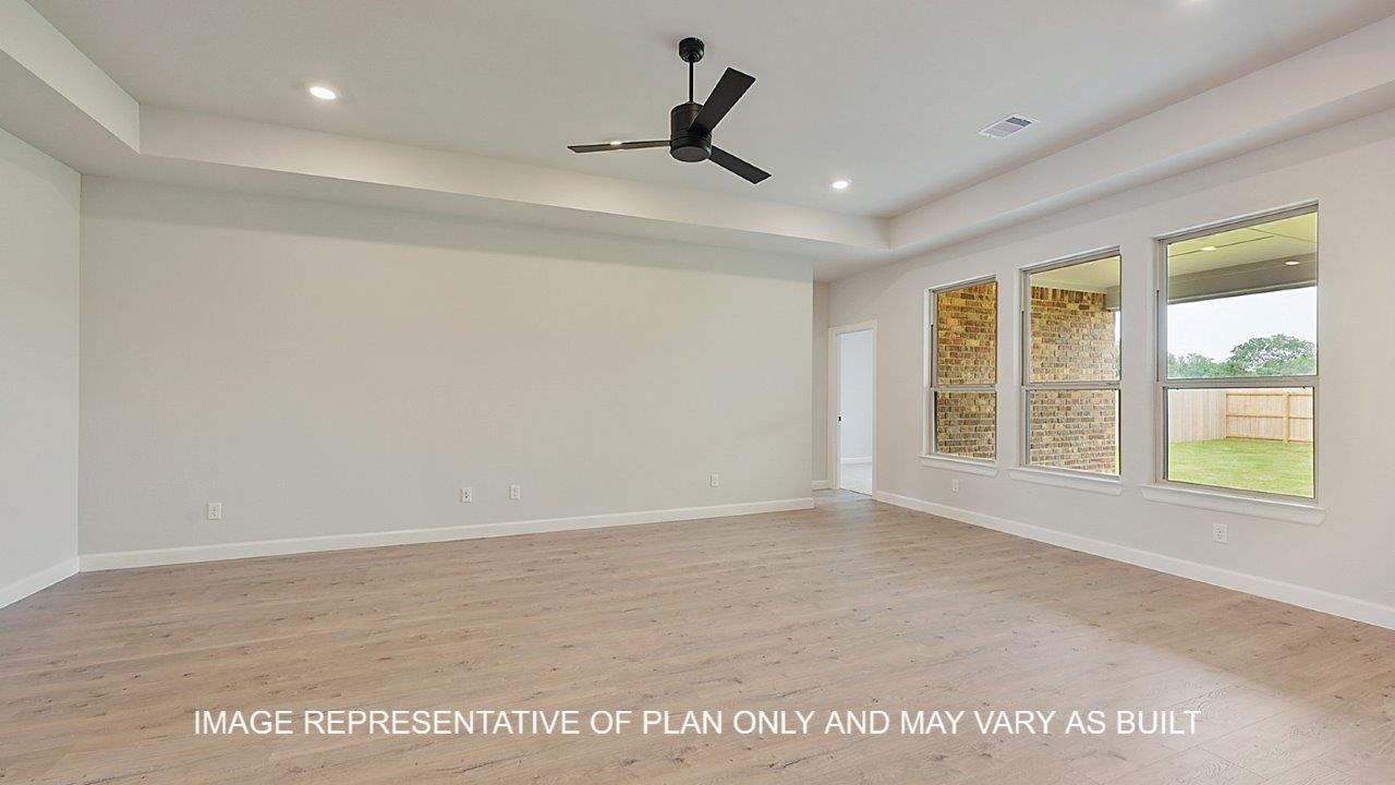Brighton living room with laminate wood flooring and windows on the back wall with view of backyard.