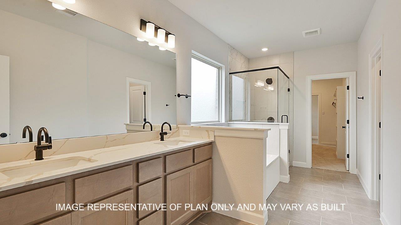 Brighton primary bathroom with tile flooring, separate tun and shower, light stained cabinets and white quartz countertops.