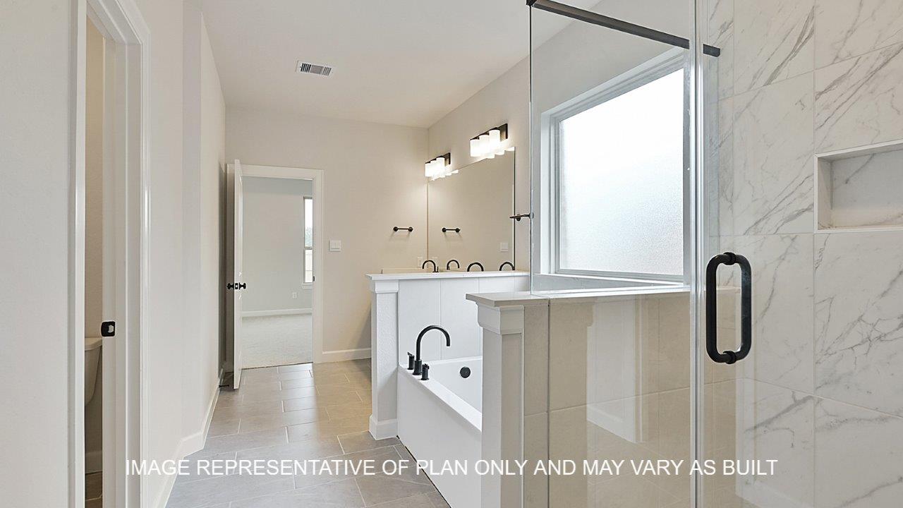 Brighton primary bathroom with tile flooring, separate tun and shower, light stained cabinets and white quartz countertops.
