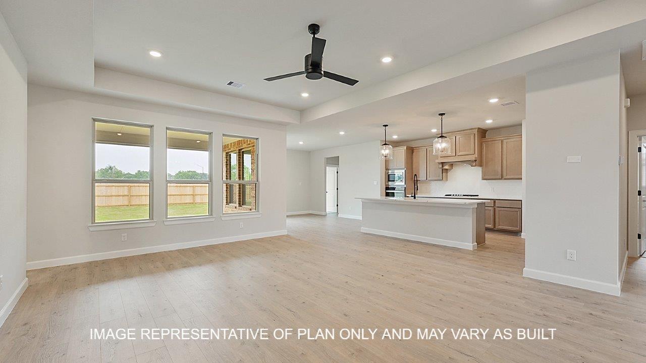 Brighton living room with laminate wood flooring and view of open concept kitchen.
