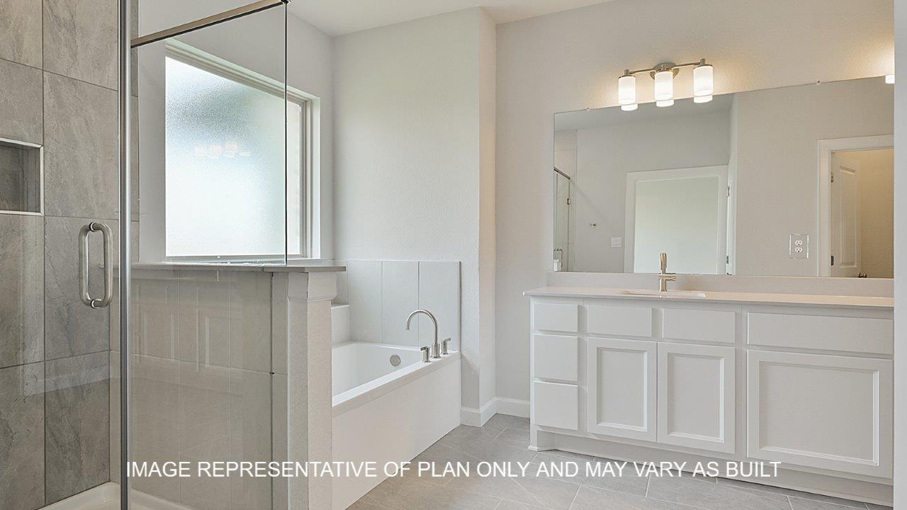 Oxford primary bathroom with tile flooring, separate tub and shower, white cabinets and white quartz countertops.