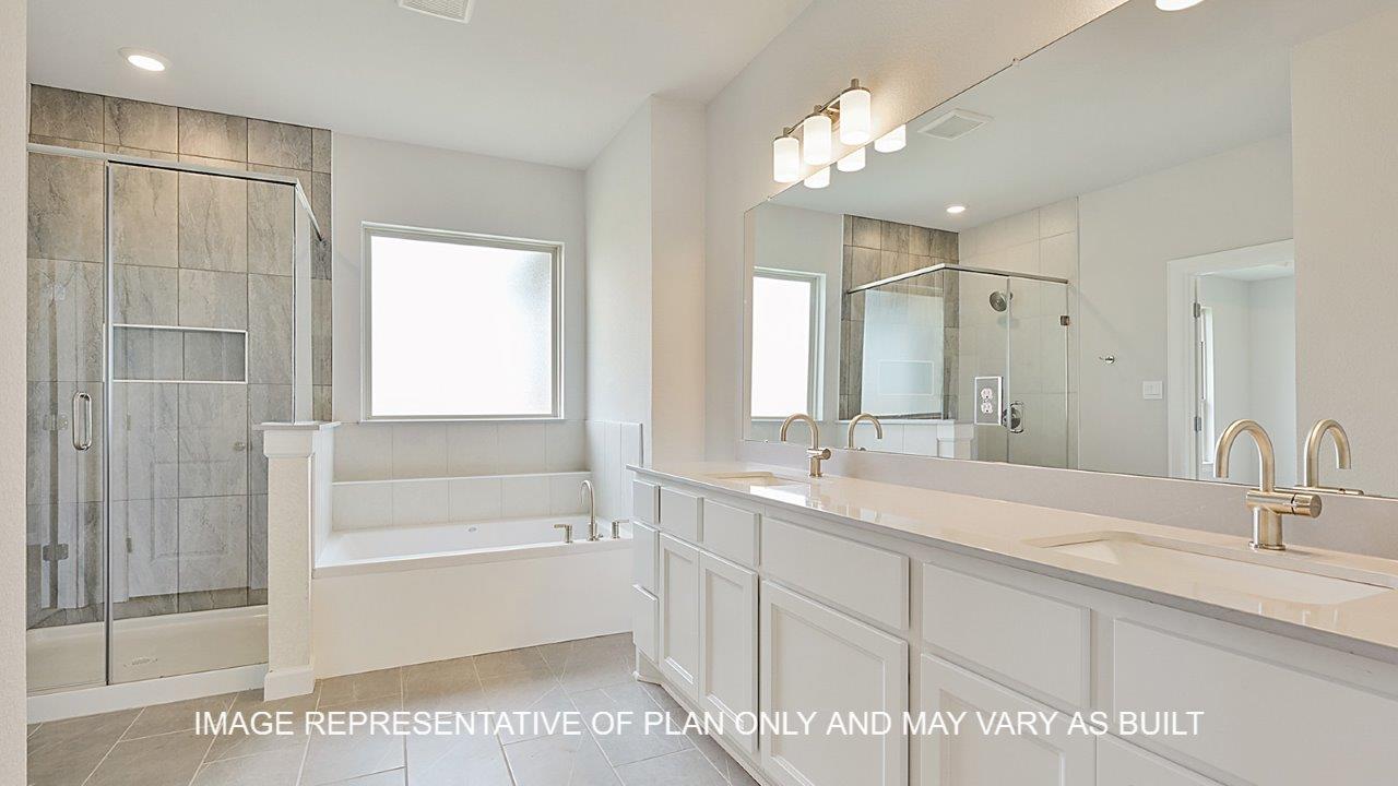 Oxford primary bathroom with tile flooring, separate tub and shower, white cabinets and white quartz countertops.