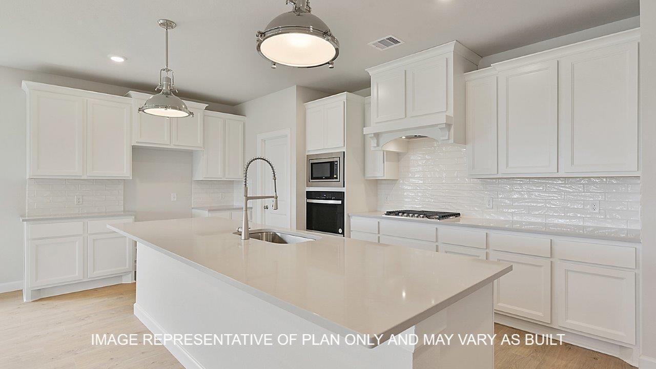 Oxford kitchen with white cabinets, white backsplash, quartz countertops and laminate wood flooring.