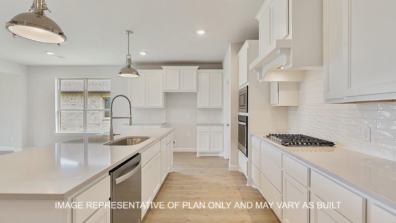 Oxford kitchen with white cabinets, white backsplash, quartz countertops and laminate wood flooring.