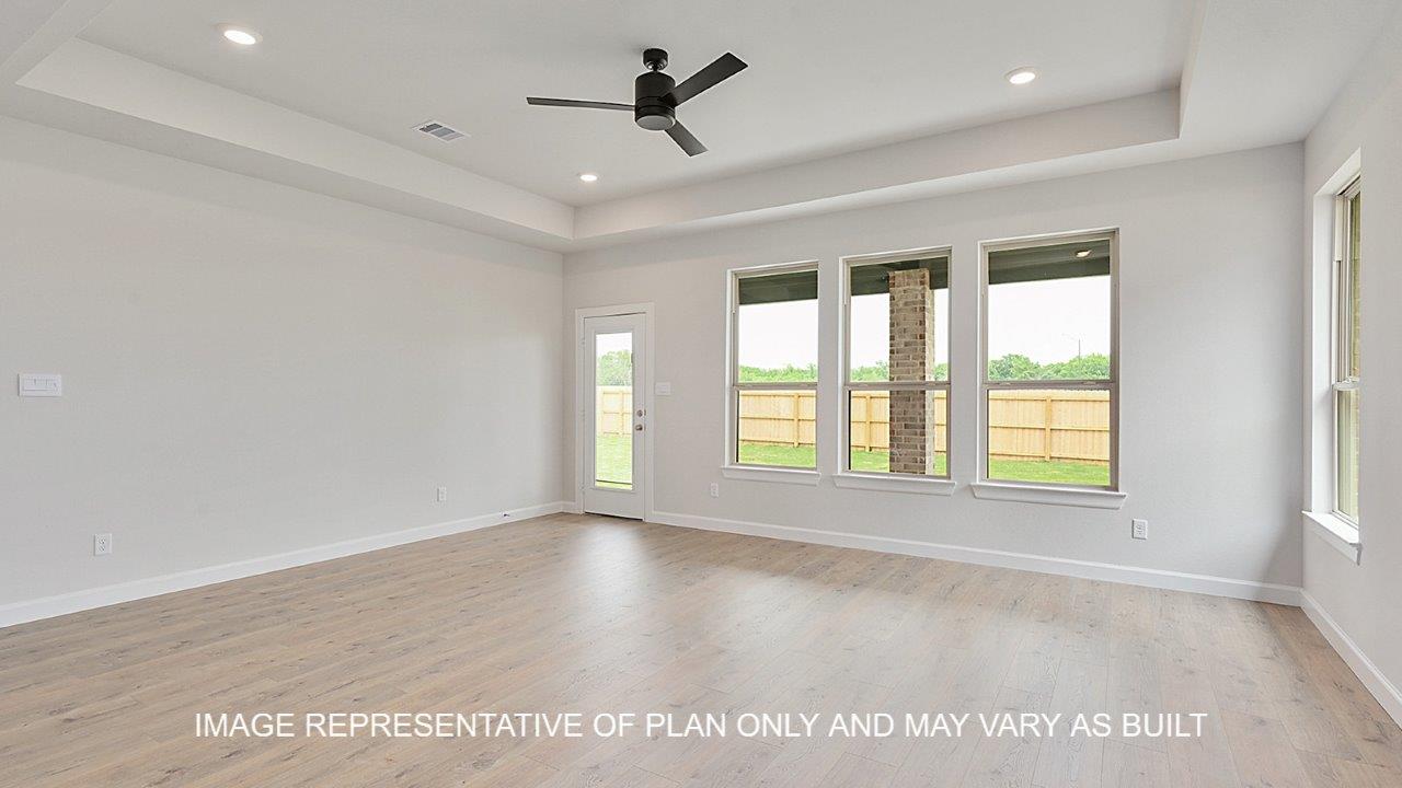 Oxford living room with laminate wood flooring and windows on the back wall with view of backyard.