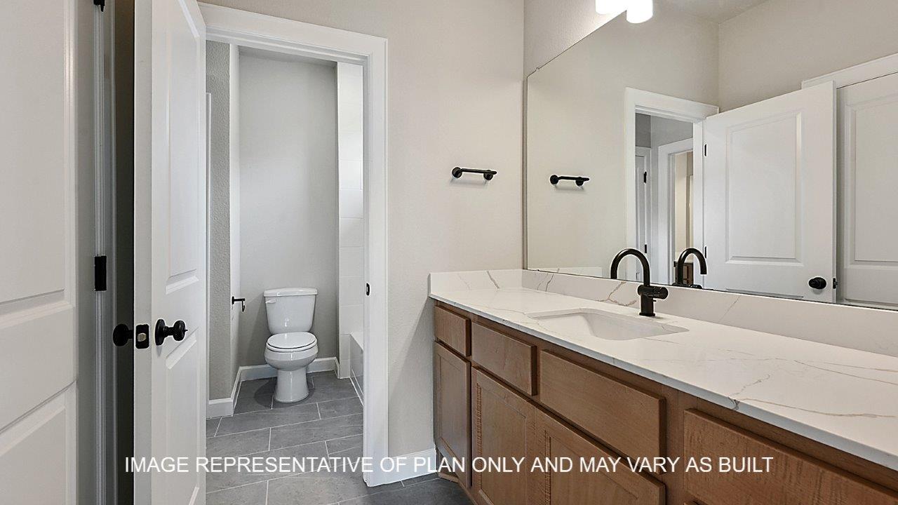 Stratford secondary bathroom with light stained cabinets, white quartz countertops and matte black fixtures.