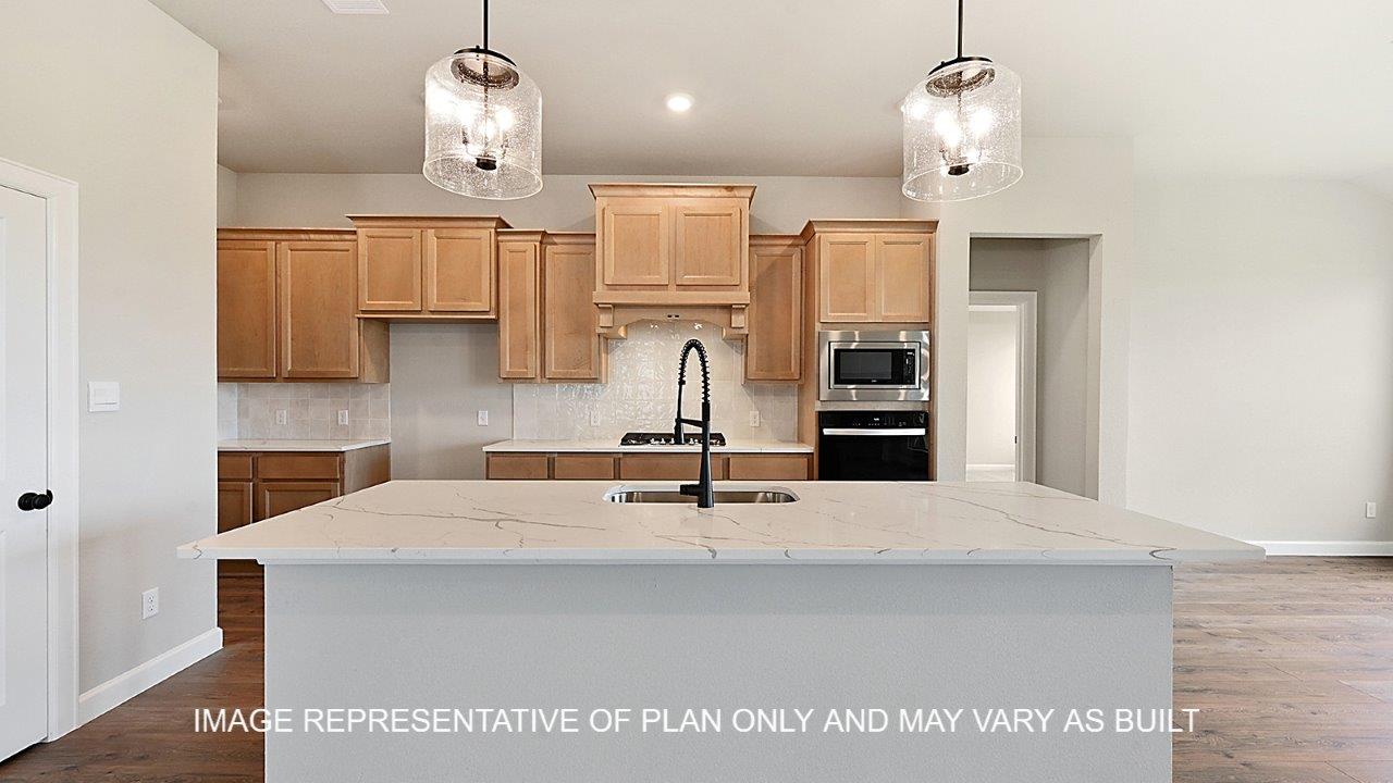 Stratford kitchen with light stained cabinets, white backsplash, quartz countertops and laminate wood flooring.