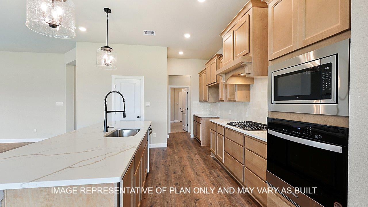 Stratford kitchen with light stained cabinets, white backsplash, quartz countertops and dark laminate wood flooring.